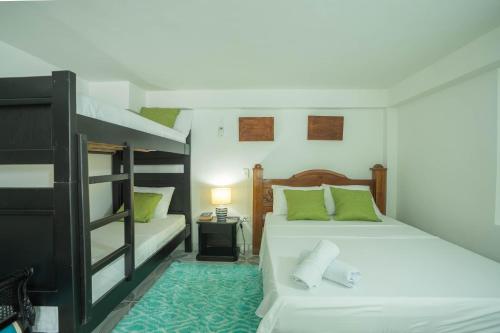 a bedroom with two bunk beds and a lamp at Posada Stoy Places in Providencia