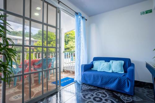 a blue couch in a room with a large window at Posada Stoy Places in Providencia