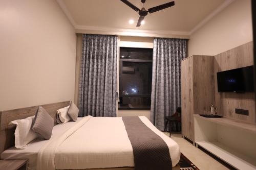 a hotel room with a bed and a television at The Tri Arrow in Khātu
