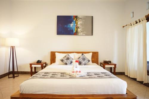 a bedroom with a bed with a stuffed animal on it at Royal Regantris Villa Karang in Gili Air
