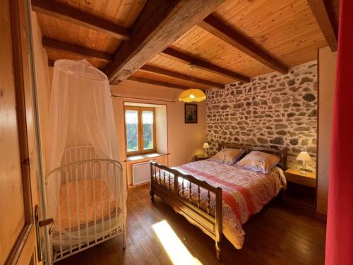 LaprugneにあるMaison de charme à la montagne avec animaux admis - FR-1-489-184のベッドと石の壁のある寝室