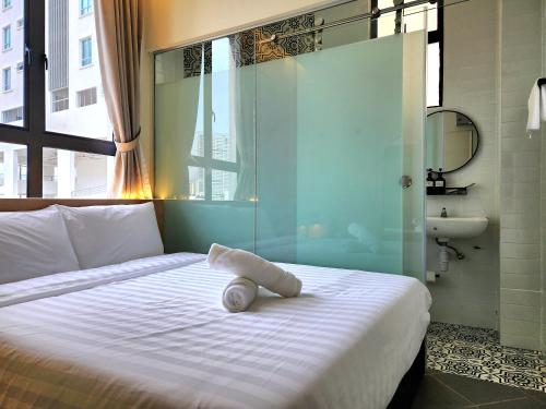 a bed with a towel on it in a room at Georgetown AY Hotel in George Town