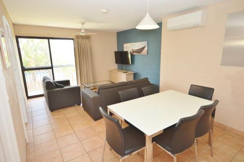 ein Wohnzimmer mit einem weißen Tisch und Stühlen in der Unterkunft Riverview Holiday Apartment 65 - Kalbarri WA in Kalbarri