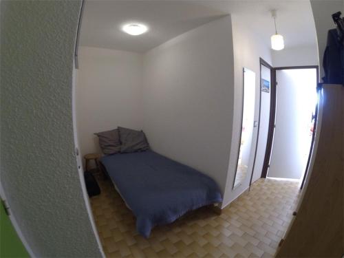 Cette petite chambre d'angle comprend un lit bleu. dans l'établissement Studio Cabine Climatisé 3 Couchages avec Terrasse et Parking Privé - Port Camargue - FR-1-731-92, au Grau-du-Roi