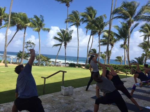 a group of people doing yoga on the beach at Family Villa Oleana Waterviews Oceanfront with water and generator in Vega Alta