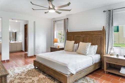 a bedroom with a large bed and a bathroom at Upscale villa in gated community beach access Yari in Vega Alta