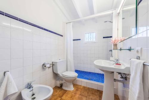 ein weißes Badezimmer mit Toilette und Waschbecken in der Unterkunft Can Patricia in Pollença