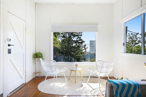 a room with three chairs and a table and a window at 2-Bed Beach House in Burleigh Heads Amidst Nature in Gold Coast