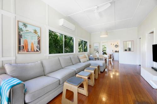a white living room with a couch and chairs at 2-Bed Beach House in Burleigh Heads Amidst Nature in Gold Coast