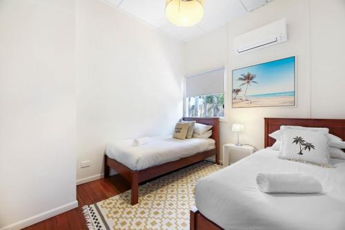 a bedroom with two beds and a window at 2-Bed Beach House in Burleigh Heads Amidst Nature in Gold Coast