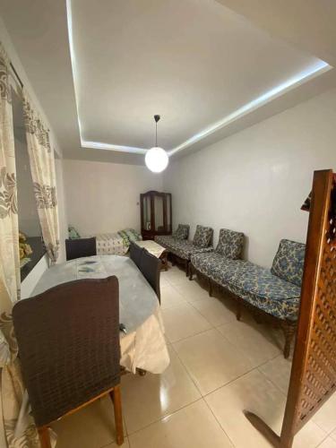 a living room with couches and a table and chairs at زهرة in Khraicia