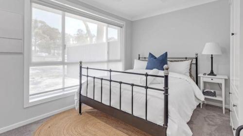 ein weißes Schlafzimmer mit einem Bett und einem Fenster in der Unterkunft Woodhill Cottage in Worrowing Heights