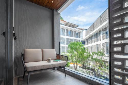 a balcony with a chair and a large window at Percent Hotel Yangshuo in Yangshuo