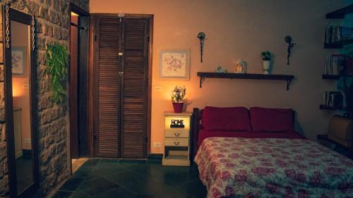 a bedroom with a bed with red pillows at Casa de Pedras na Montanha Stone House in Atibaia
