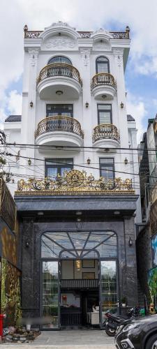 a large white building with a goldvisor over a doorway at Q Villa Hotel in Xuan An