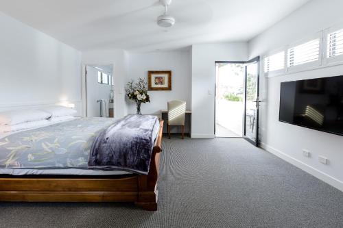 a bedroom with a bed and a flat screen tv at Karri Keep - Spacious 3 Bedroom Town Villa in Margaret River Town