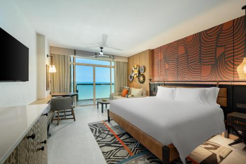 a hotel room with a large bed and a living room at Centara Grand Mirage Beach Resort Pattaya in North Pattaya