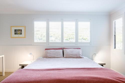 a white bedroom with a large bed and windows at Karri Keep - Spacious 3 Bedroom Town Villa in Margaret River Town