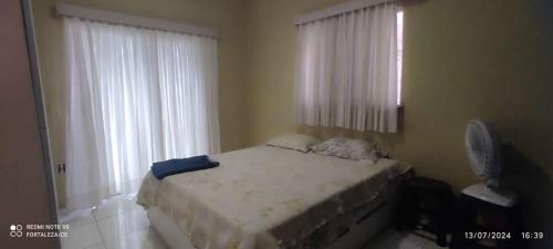 a bedroom with a bed and a large window at Espaço de descanso in Fortaleza