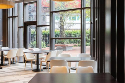 a cafeteria with tables and chairs and large windows at CHECK inn MAGI Kids Hotel in Luodong