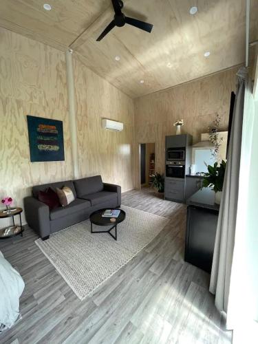 a living room with a couch and a kitchen at LyeInn - Newstead Country Retreat in Newstead