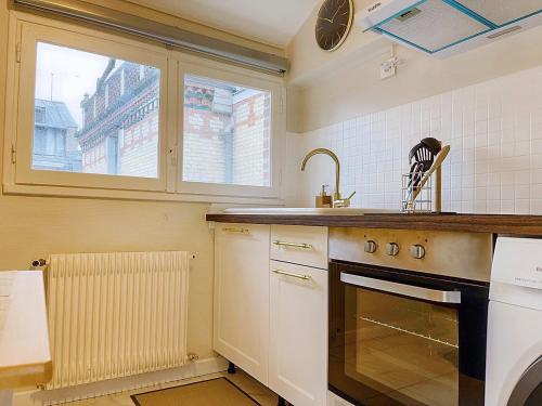 a kitchen with a stove and a sink and a window at Magnifique Cocon Calme et Moderne en Hypercentre in Blois
