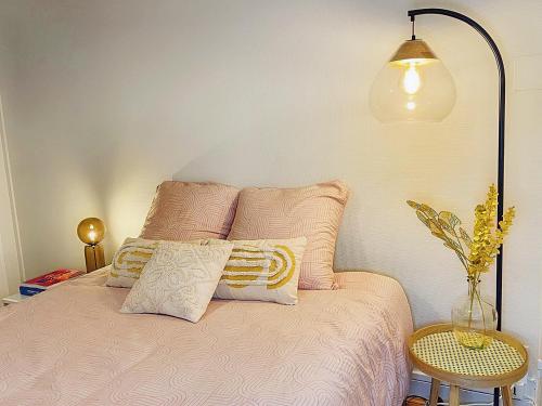 a bedroom with a bed with pink sheets and a lamp at Magnifique Cocon Calme et Moderne en Hypercentre in Blois