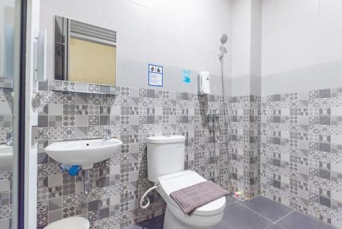 a bathroom with a toilet and a sink at Urbanview Darmo Residence Bandung in Bandung