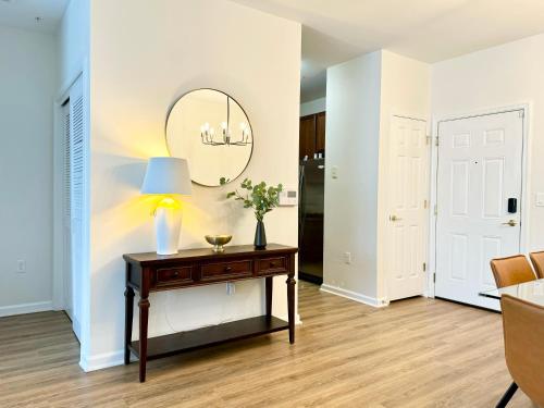 a living room with a table and a mirror at Luxury Condo Near NYC, MetLife & American Dream in Passaic