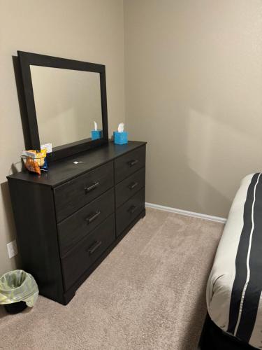a bedroom with a dresser with a mirror on it at Humble Home in Aurora