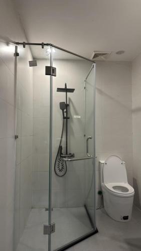 a bathroom with a shower with a toilet and a cross at Rose's Homestay Hue in Hue
