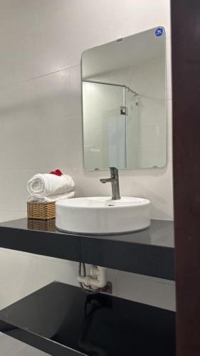 a bathroom with a white sink and a mirror at Rose's Homestay Hue in Hue