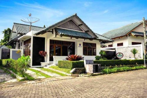 a house with a brick road in front of it at Puncak Villa Lotus D33 in Cipanas