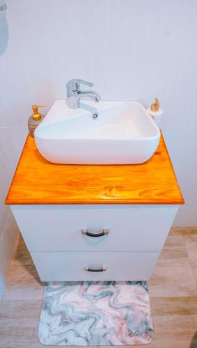 a white sink on a wooden counter in a bathroom at Serene Corner Nest in Gaborone