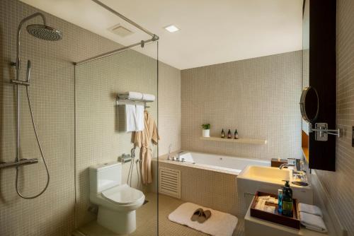 a bathroom with a shower and a toilet and a sink at Mangala Estate Boutique Resort - Small Luxury Hotels of the World in Kuantan