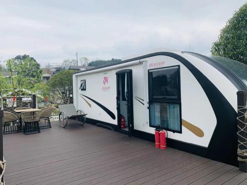 a large white trailer on a deck at Zhangjiajie Cliff Flower RV Tent Hotel in Sanguansi