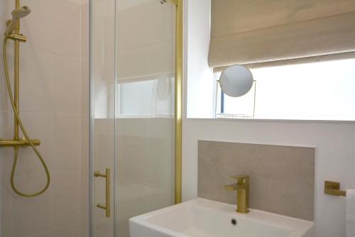 a bathroom with a shower and a white sink at Tree Tops in Lulsgate Bottom
