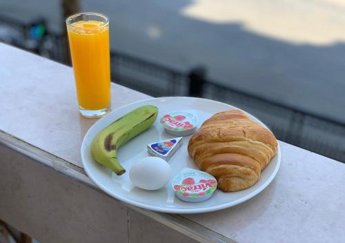 a plate of food with a banana and an egg and a croissant at City Stars Hotel in Cairo