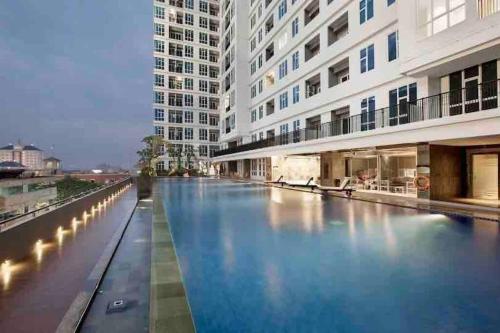 una gran piscina en medio de un edificio en Pool View One Bedroom Apartment BSD with Kitchen, en Dadap