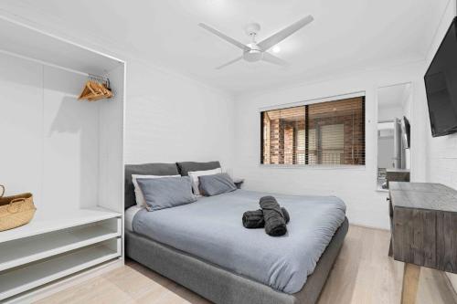 a bedroom with a large bed with a ceiling fan at 2 Cute by Experience Jervis Bay in Huskisson