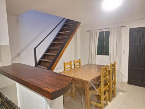 a dining room with a wooden table and a staircase at Espacioso dúplex, ubicación premium in San Luis