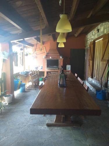 une grande table en bois dans une grande pièce avec une lumière dans l'établissement Ca Toñi, à Santoréns