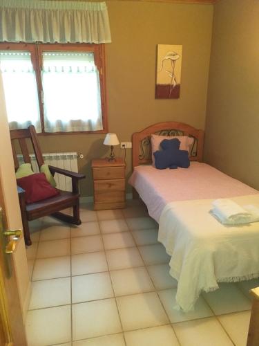 une chambre avec deux lits et une chaise dans l'établissement Ca Toñi, à Santoréns