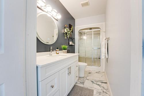 a white bathroom with a sink and a mirror at Luxury Beach Cottage - Maijac Resort & Marina in Burks Falls