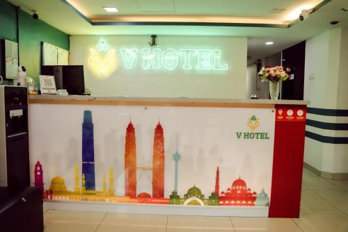 a sign for a hotel with a mural of cities at V Hotel Titiwangsa in Kuala Lumpur