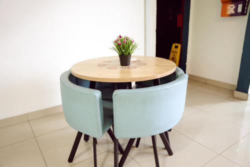 a wooden table with two blue chairs around it at V Hotel Titiwangsa in Kuala Lumpur
