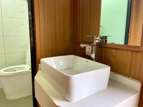 a bathroom with a white sink and a toilet at Zhangjiajie Cliff Flower RV Tent Hotel in Sanguansi