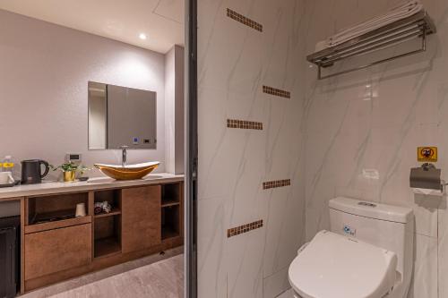 a bathroom with a toilet and a sink at CHECK inn Taichung Qinghai in Taichung