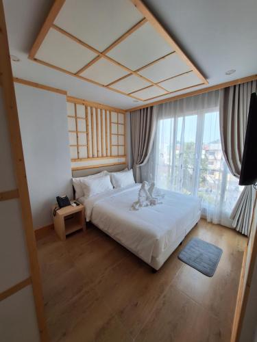 a bedroom with a large bed and a large window at V.I.P BOUTIQUE HOTEL in Vientiane