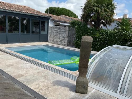 - une piscine avec un point d'eau dans une maison dans l'établissement Maison 3 ch avec accès piscine chauffée couverte, à Rivedoux-Plage